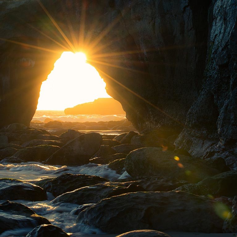 View Looking out of an Ocean Cave Towards the Rising Sun